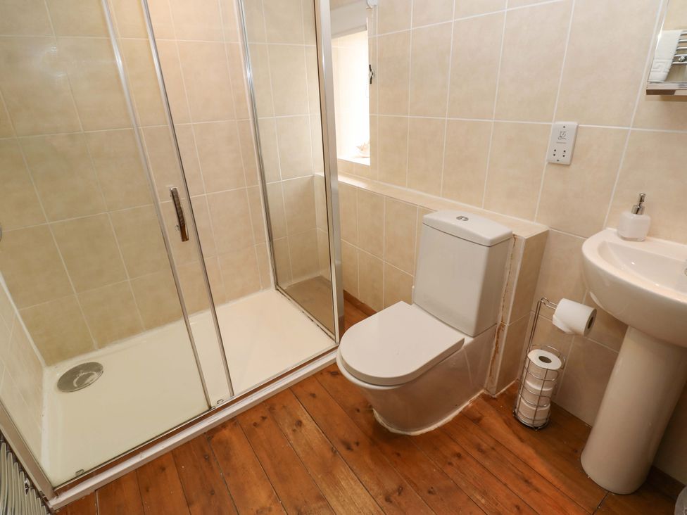 A bathroom with a shower, toilet, and sink at The Hay Barn 
