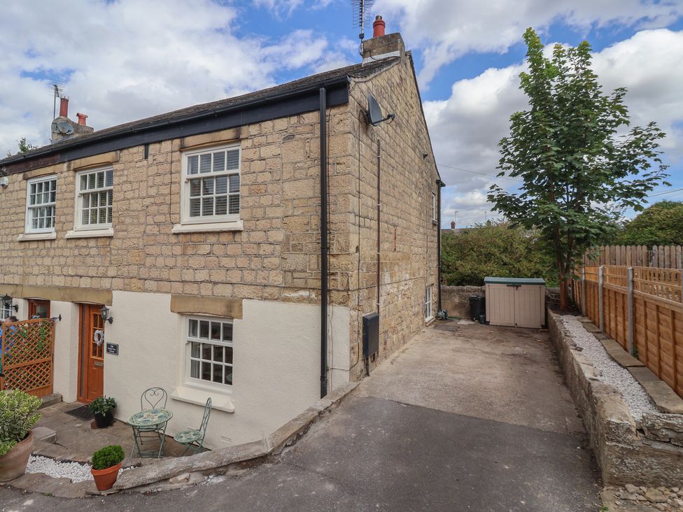 An outdoor area with seating and a tree at Maple Tree Cottage, Knaresborough