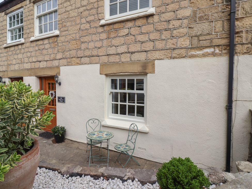 An outdoor seating area with a table and chairs at Maple Tree Cottage in Knaresborough