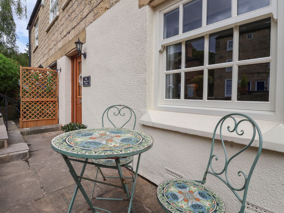 An outdoor seating area with a table and chairs at Maple Tree Cottage Knaresborough