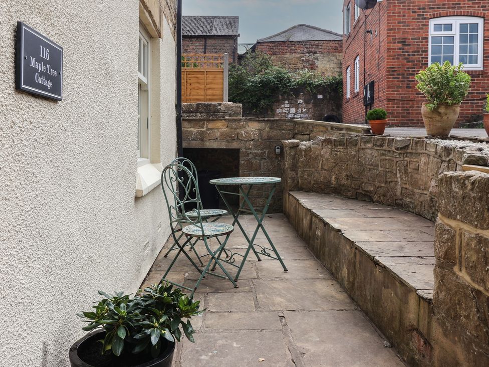 An outdoor area with a table and chairs at Maple Tree Cottage in Knaresborough