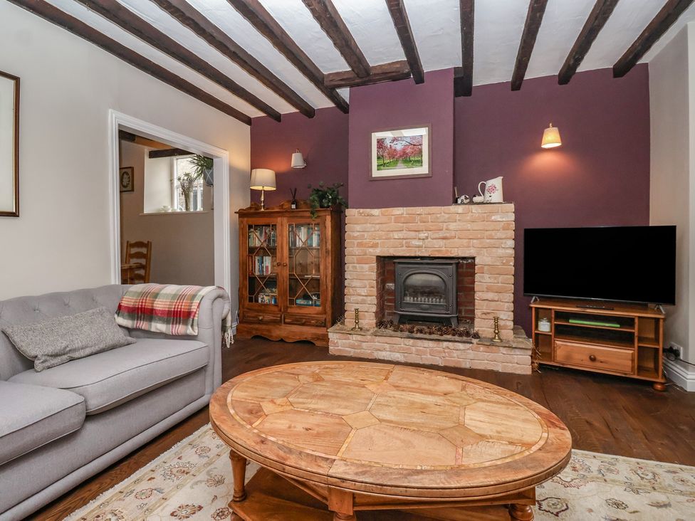 A living room with a fireplace and a television at Maple Tree Cottage Knaresborough