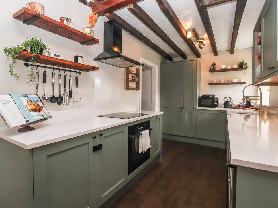 A kitchen with cabinets and shelves at Maple Tree Cottage in Knaresborough