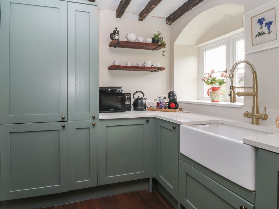 A kitchen with cabinets and a sink at Maple Tree Cottage in Knaresborough