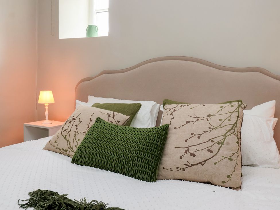 A bedroom with a bed and decorative pillows at Maple Tree Cottage in Knaresborough