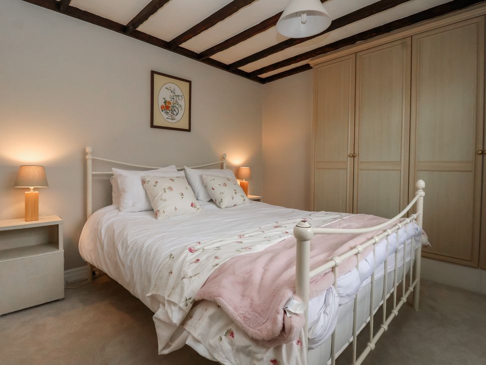 A bedroom with a bed and bedside lamps at Maple Tree Cottage in Knaresborough