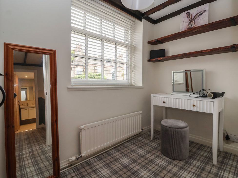 A bedroom with a vanity table and mirror at Maple Tree Cottage in Knaresborough