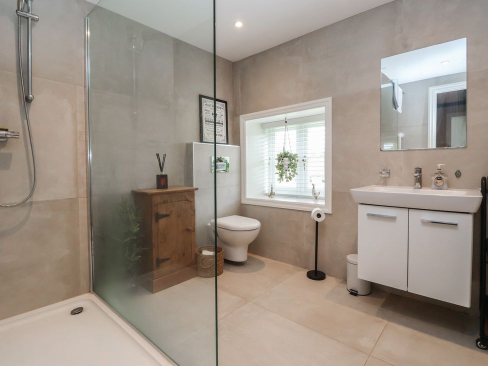 A bathroom with a shower, toilet, and sink at Maple Tree Cottage, Knaresborough