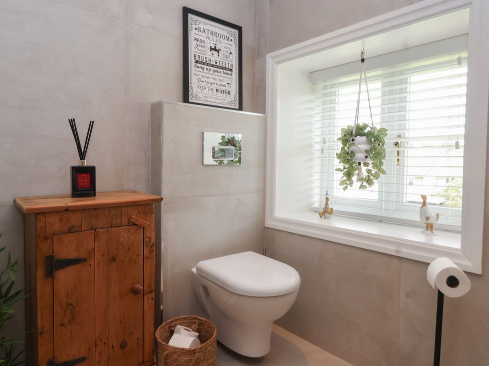A bathroom with a toilet and cabinet at Maple Tree Cottage Knaresborough