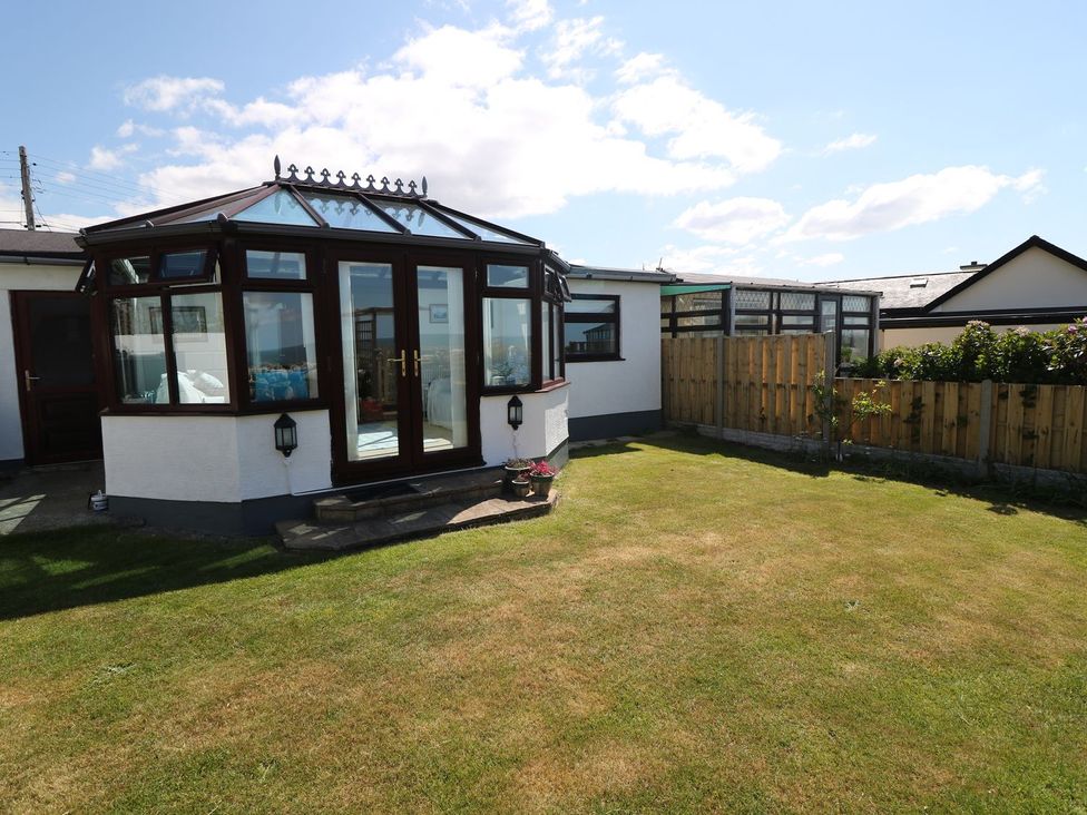 A conservatory with grass and a fence at Goetra
