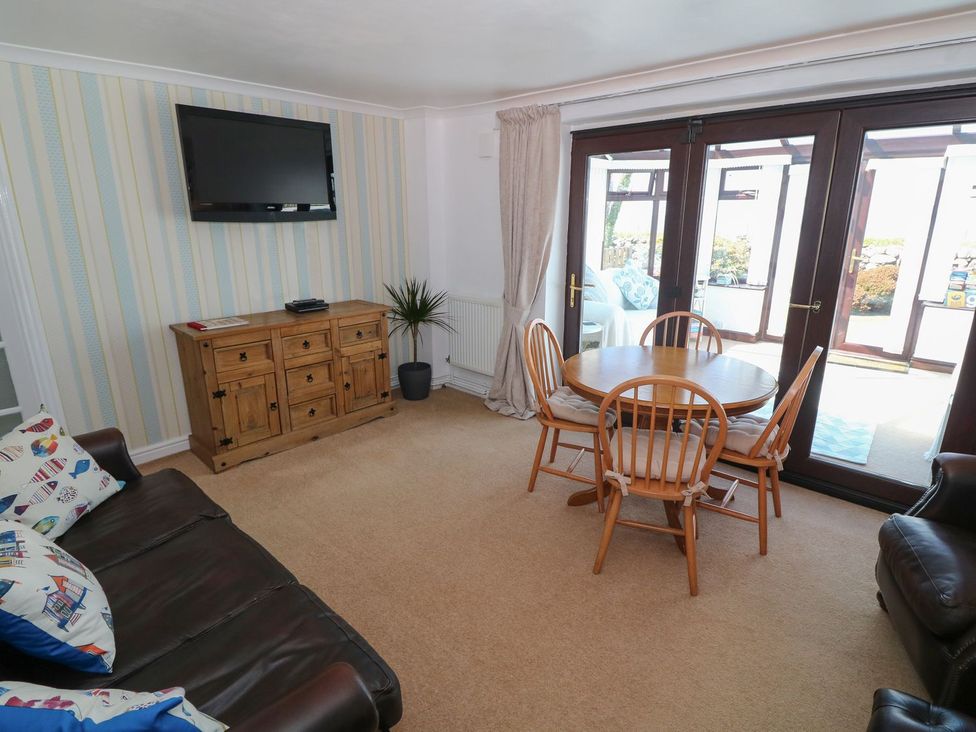 A living room with a dining table and television at Goetra