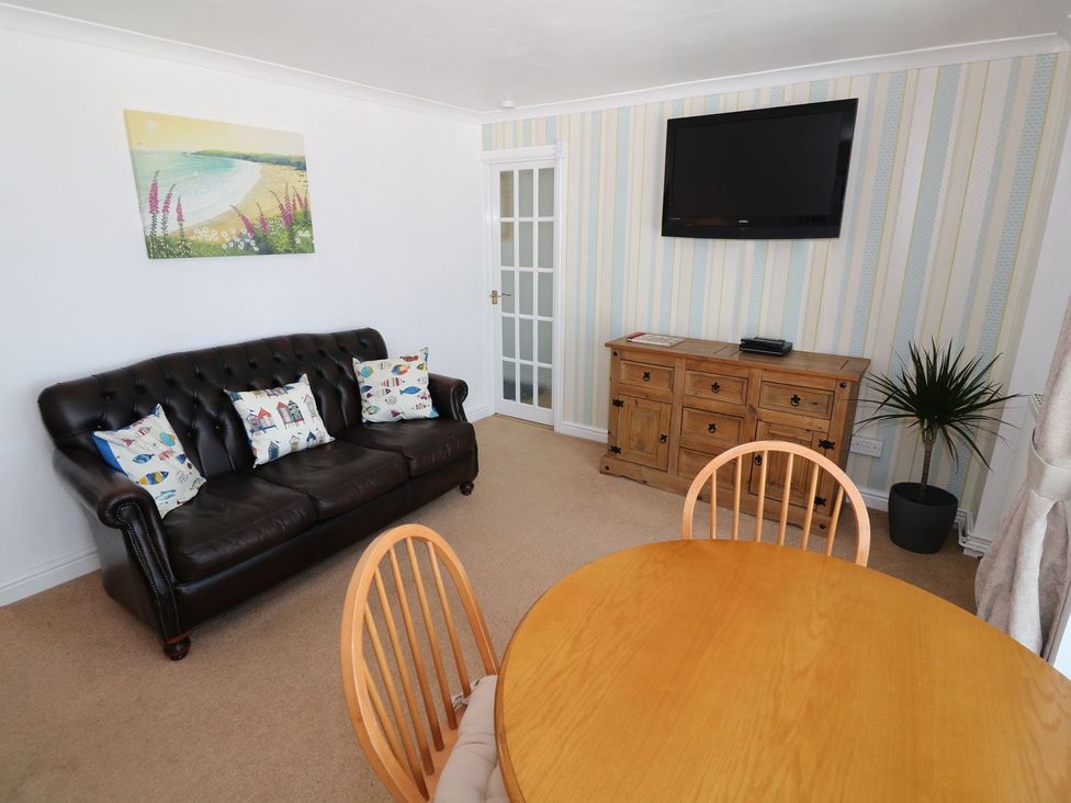 A living room with a sofa, table, chairs, and television at Goetra