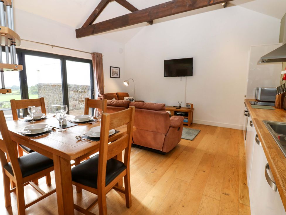 A living room with a sofa and dining area at The Warren Barn in Kirkby Malzeard