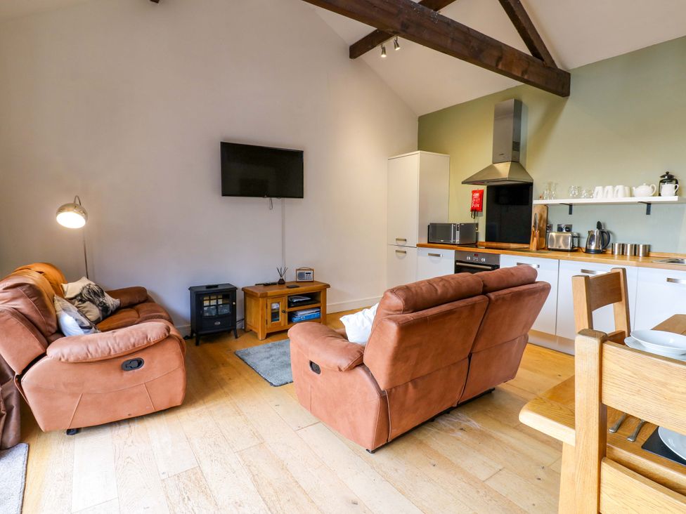 A living room with recliners and kitchen appliances at The Warren Barn in Kirkby Malzeard