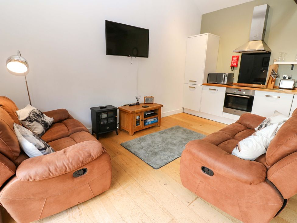 A living room with sofas and a television at The Warren Barn in Kirkby Malzeard