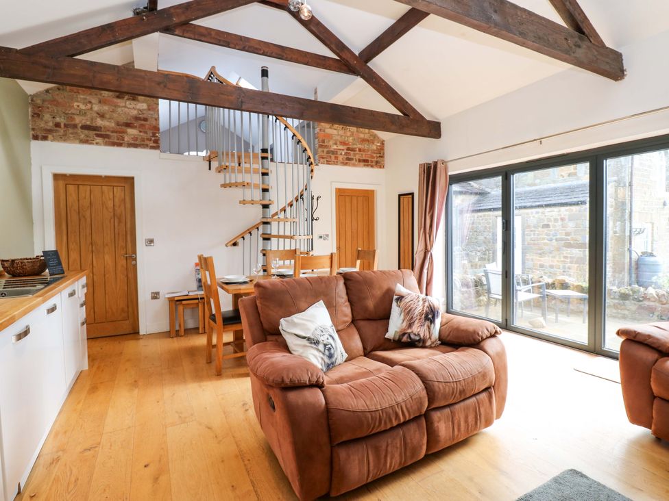 A living room with a sofa and dining table at The Warren Barn in Kirkby Malzeard