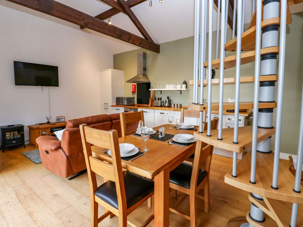 A living room with a dining area and kitchen at The Warren Barn in Kirkby Malzeard