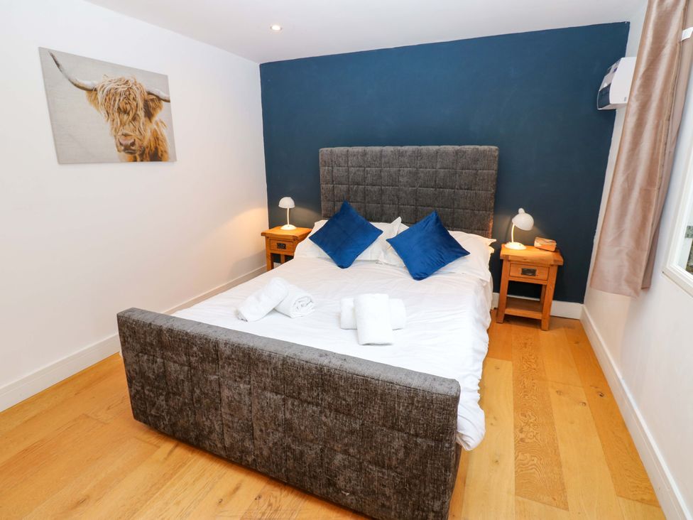 A bedroom with a bed and nightstands at The Warren Barn in Kirkby Malzeard