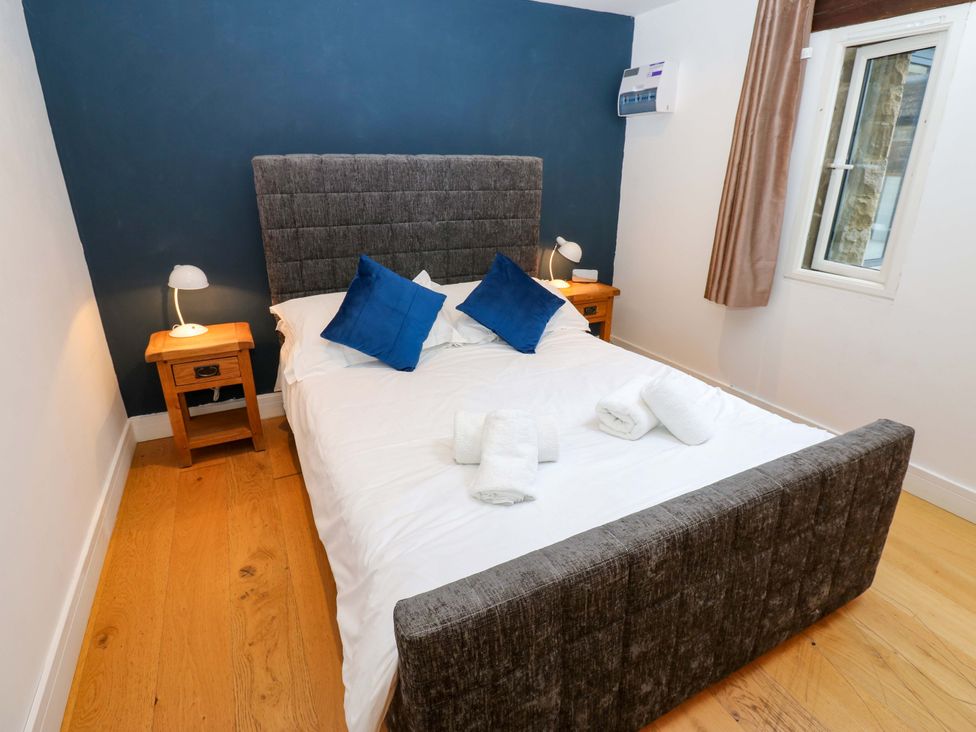 A bedroom with a bed and bedside table at The Warren Barn in Kirkby Malzeard
