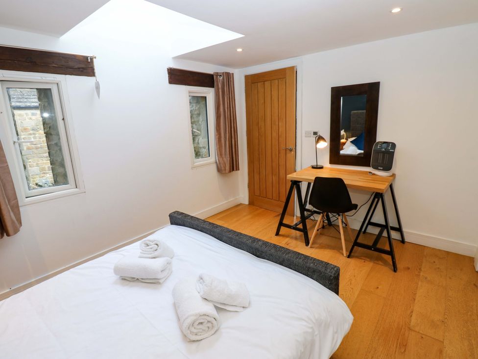 A bedroom with a bed, desk and chair at The Warren Barn in Kirkby Malzeard