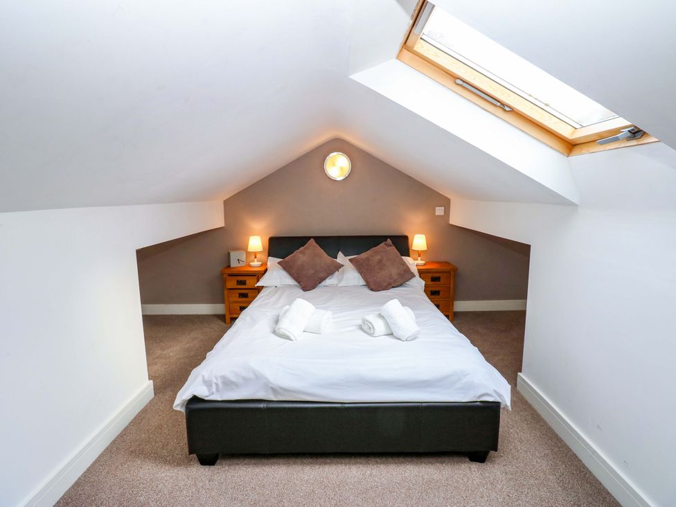 A bedroom with a bed and bedside tables at The Warren Barn in Kirkby Malzeard