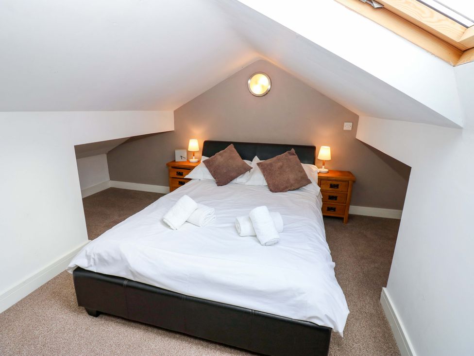 A bedroom with a bed and bedside tables at The Warren Barn in Kirkby Malzeard
