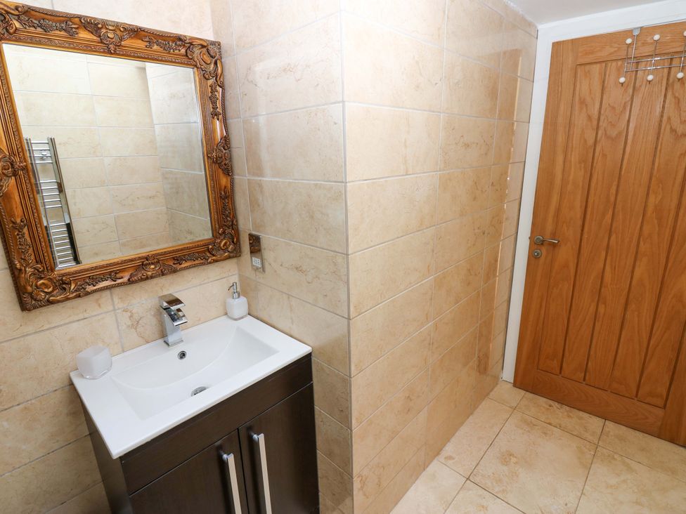 A bathroom with a sink and mirror at The Warren Barn in Kirkby Malzeard