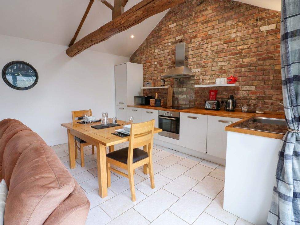 A kitchen area with a dining table and chairs at The Holt Barn in Kirkby Malzeard