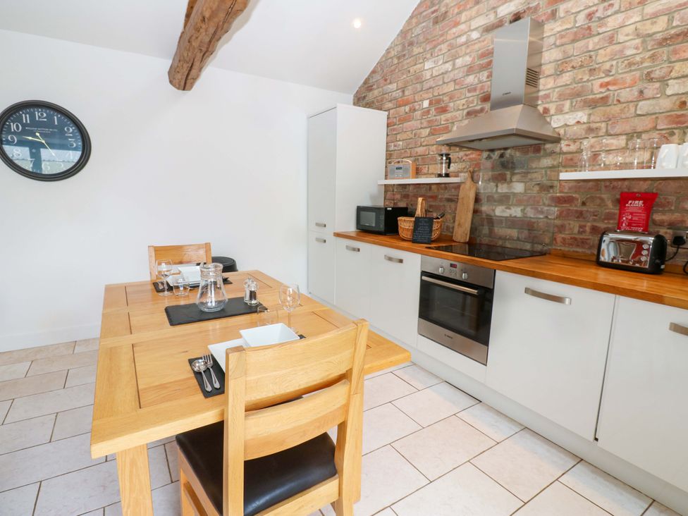 A kitchen with a dining table and appliances at The Holt Barn in Kirkby Malzeard