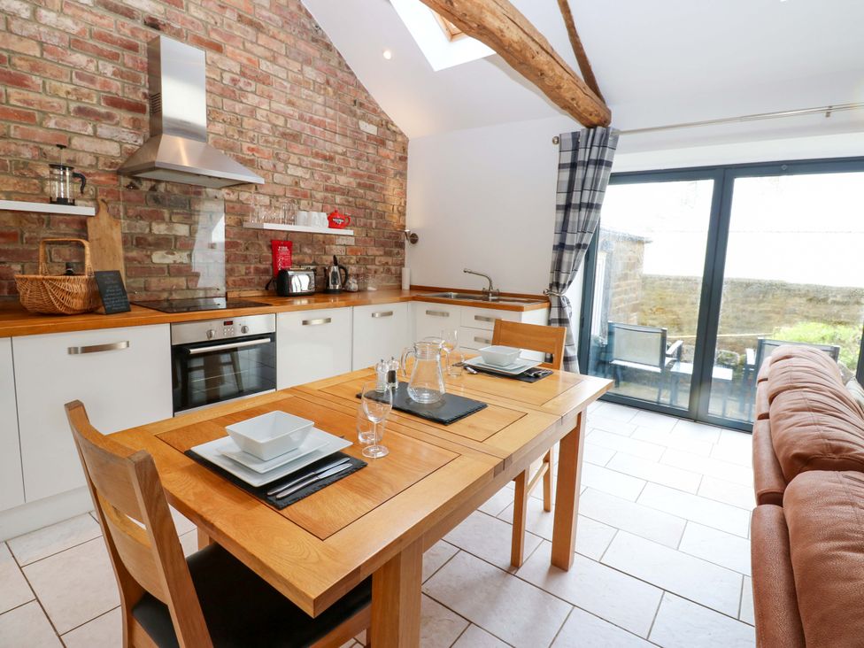 A kitchen with dining table and chairs at The Holt Barn in Kirkby Malzeard