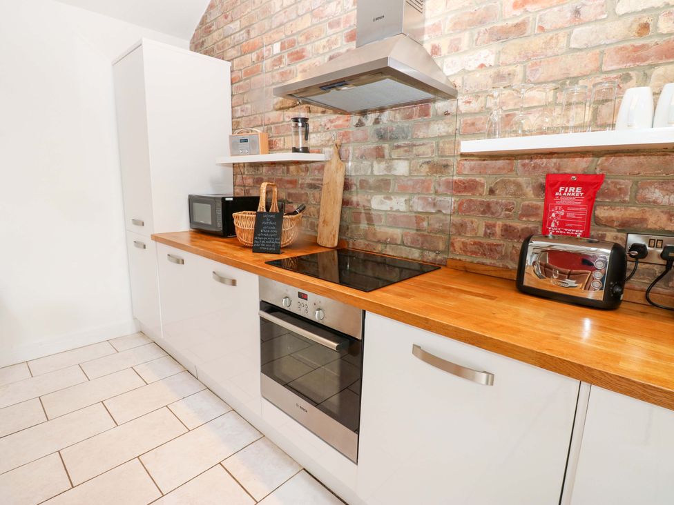 A kitchen with appliances and wooden counter at The Holt Barn in Kirkby Malzeard