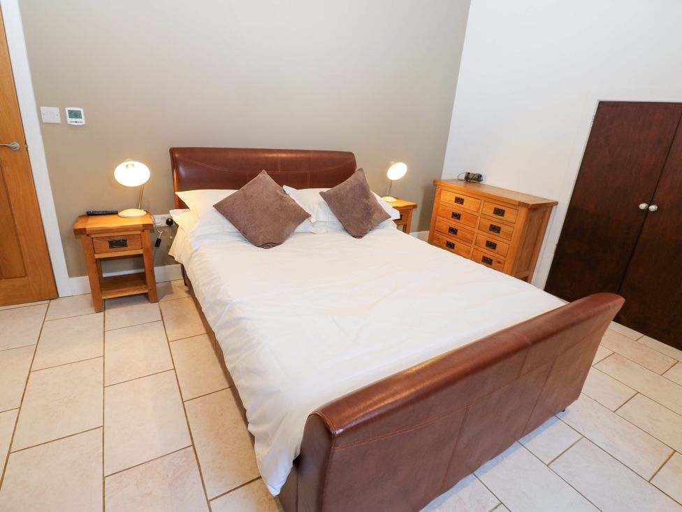 A bedroom with a bed and bedside table at The Holt Barn in Kirkby Malzeard