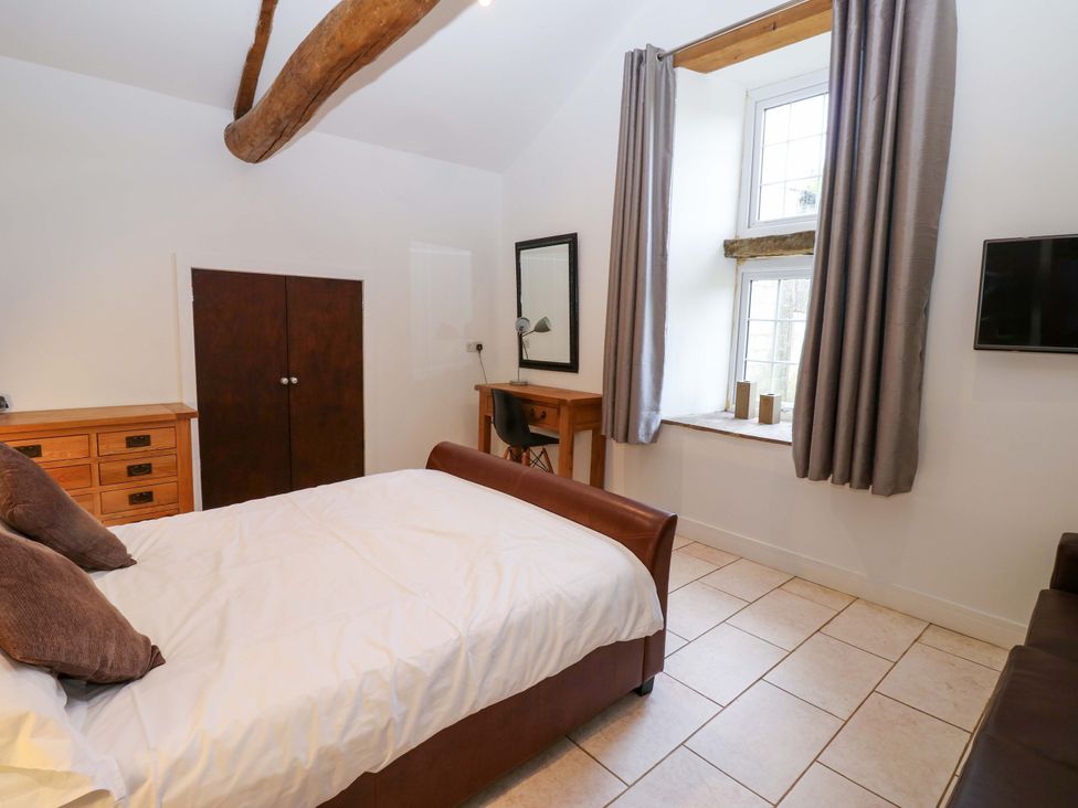 A bedroom with a bed and dresser at The Holt Barn in Kirkby Malzeard