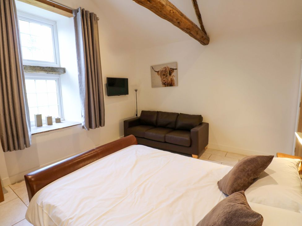 A bedroom with a bed and sofa at The Holt Barn in Kirkby Malzeard
