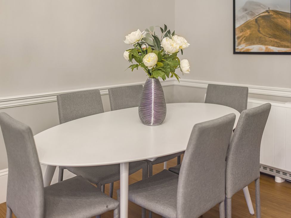 A dining room with an oval table and vase of flowers at Central Vista Retreat in Chester