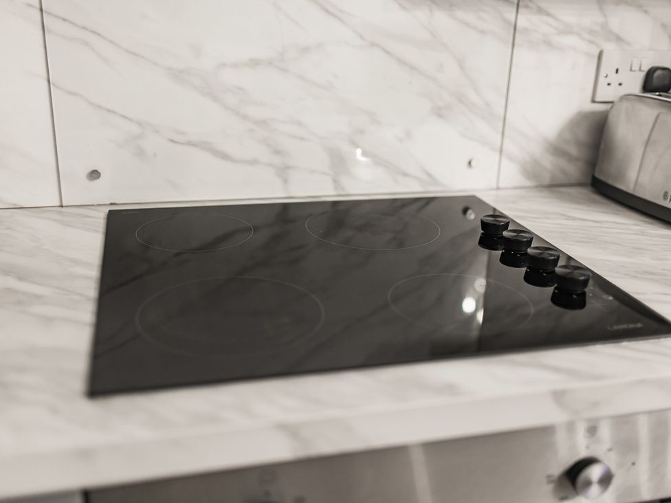 A cooker with knobs on a marble countertop at Central Vista Retreat in Chester