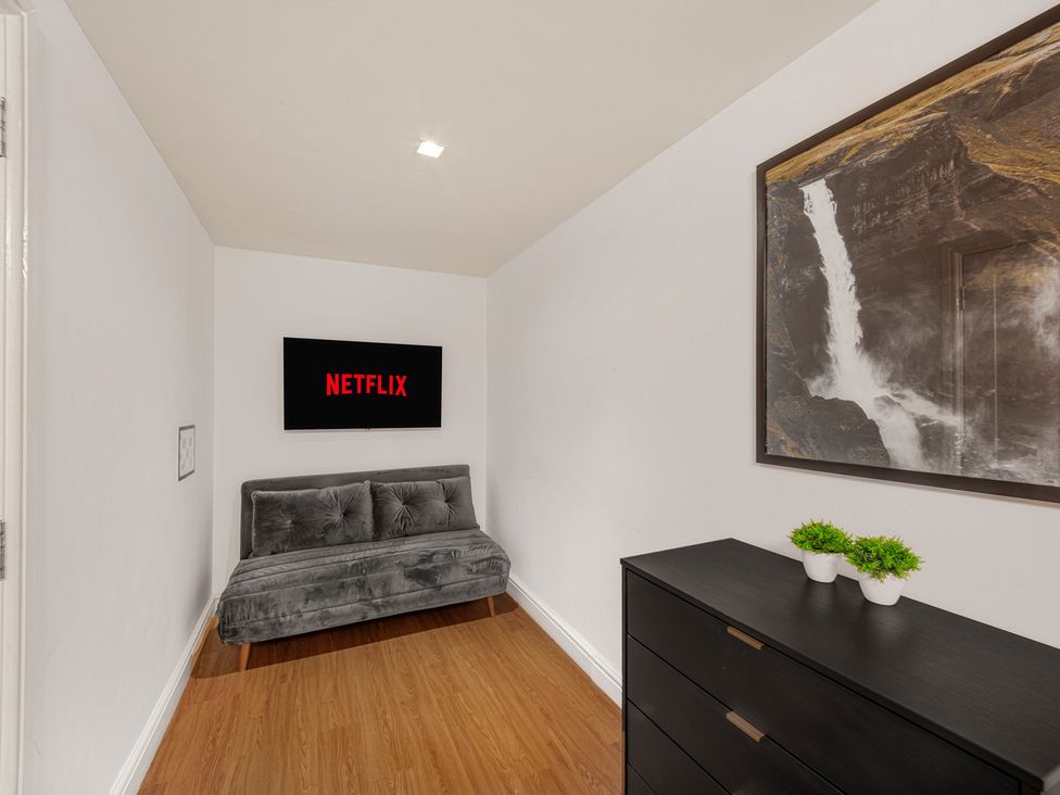 A seating area with a television and dresser at Central Vista Retreat in Chester