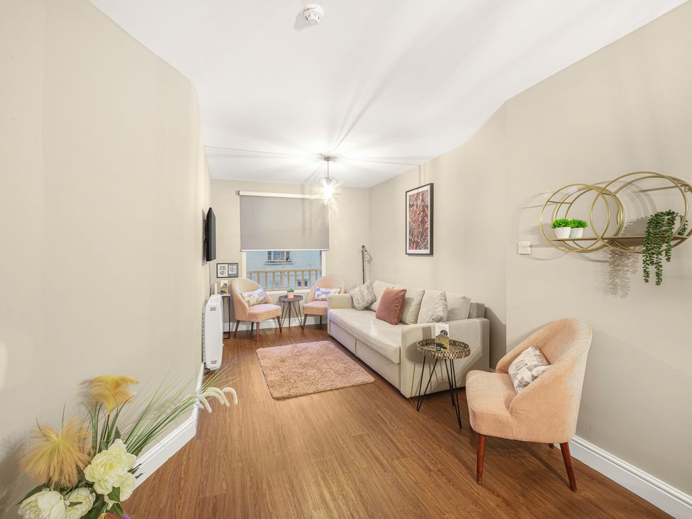 A living room with a sofa, coffee table, and television at Ravenswood Penthouse in Chester