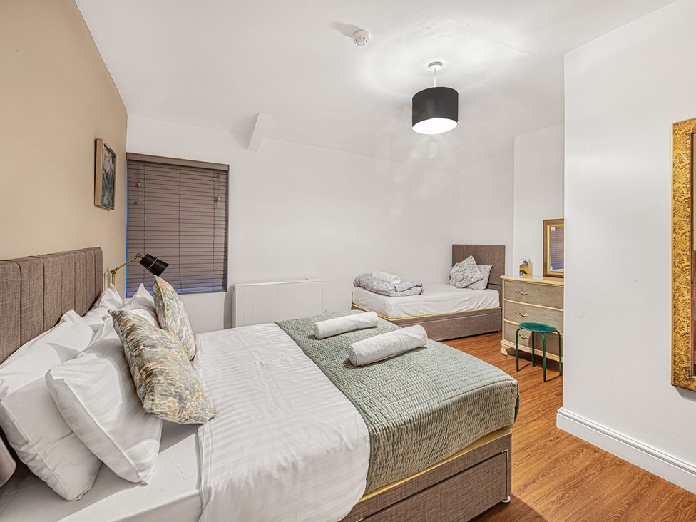 A bedroom with two beds and a dressing table at Ravenswood Penthouse in Chester