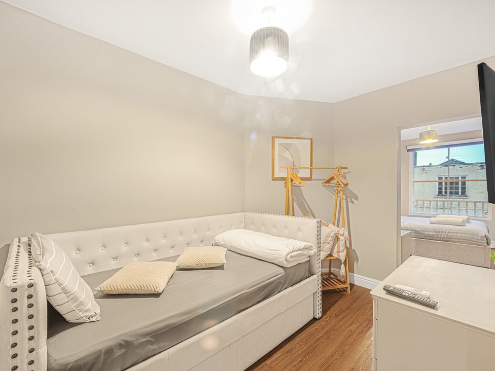 A bedroom with a bed and a clothes rack at Ravenswood Penthouse in Chester