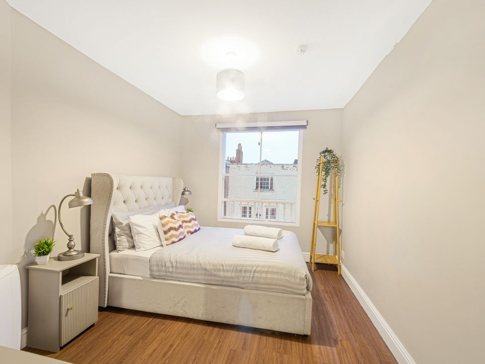 A bedroom with a bed and window at Ravenswood Penthouse in Chester