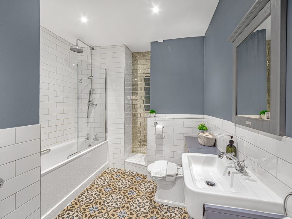 A bathroom with a bathtub, shower, sink, and toilet at Ravenswood Penthouse in Chester
