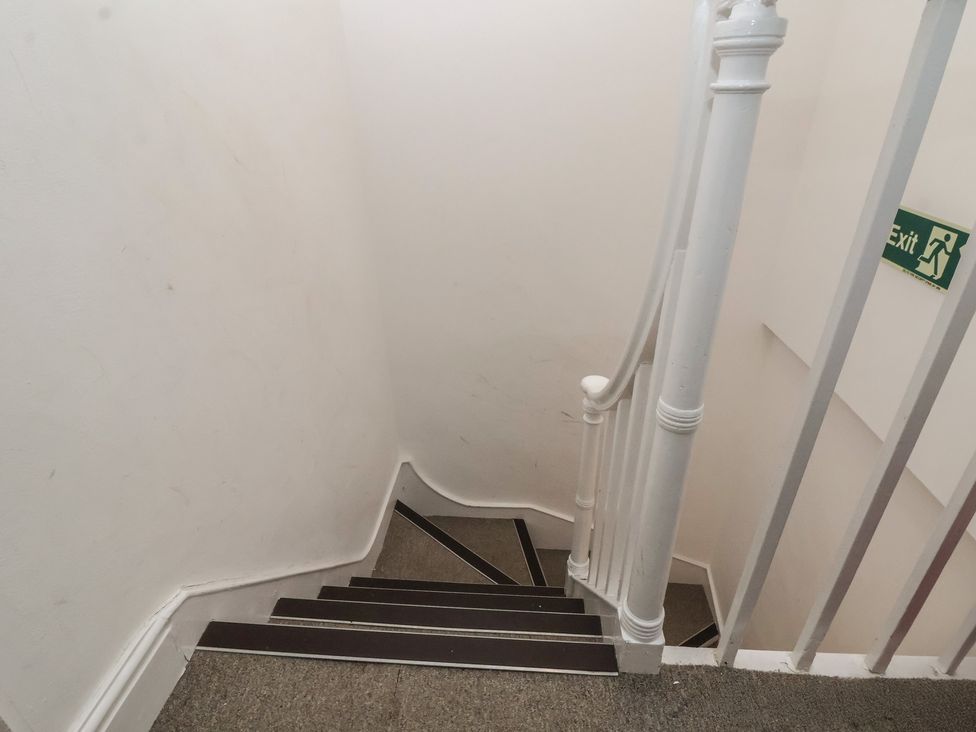 Stairs with a handrail and an exit sign at Ravenswood Penthouse Chester