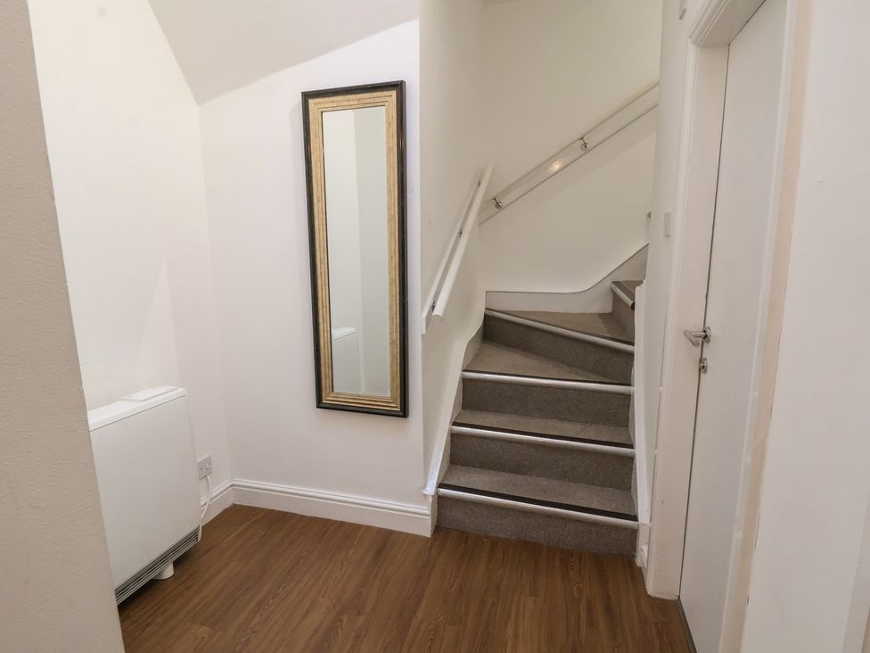 A hallway with a staircase and mirror at Ravenswood Penthouse in Chester