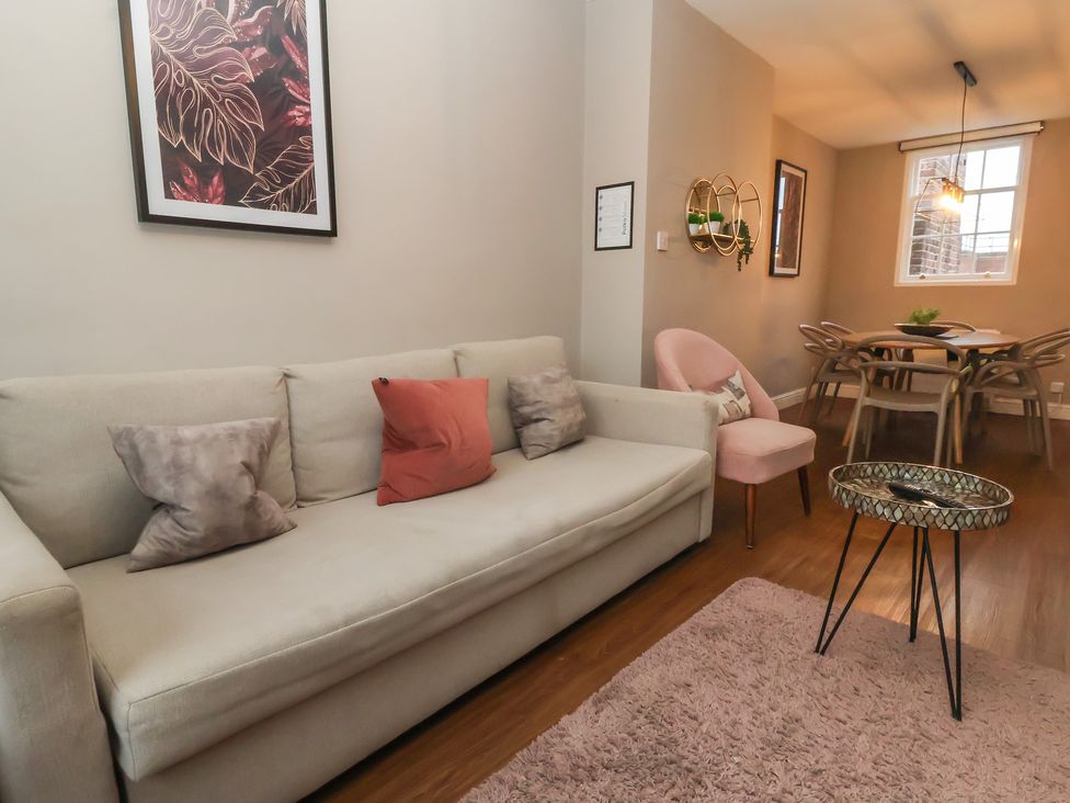 A living room with a sofa and dining area at Ravenswood Penthouse Chester