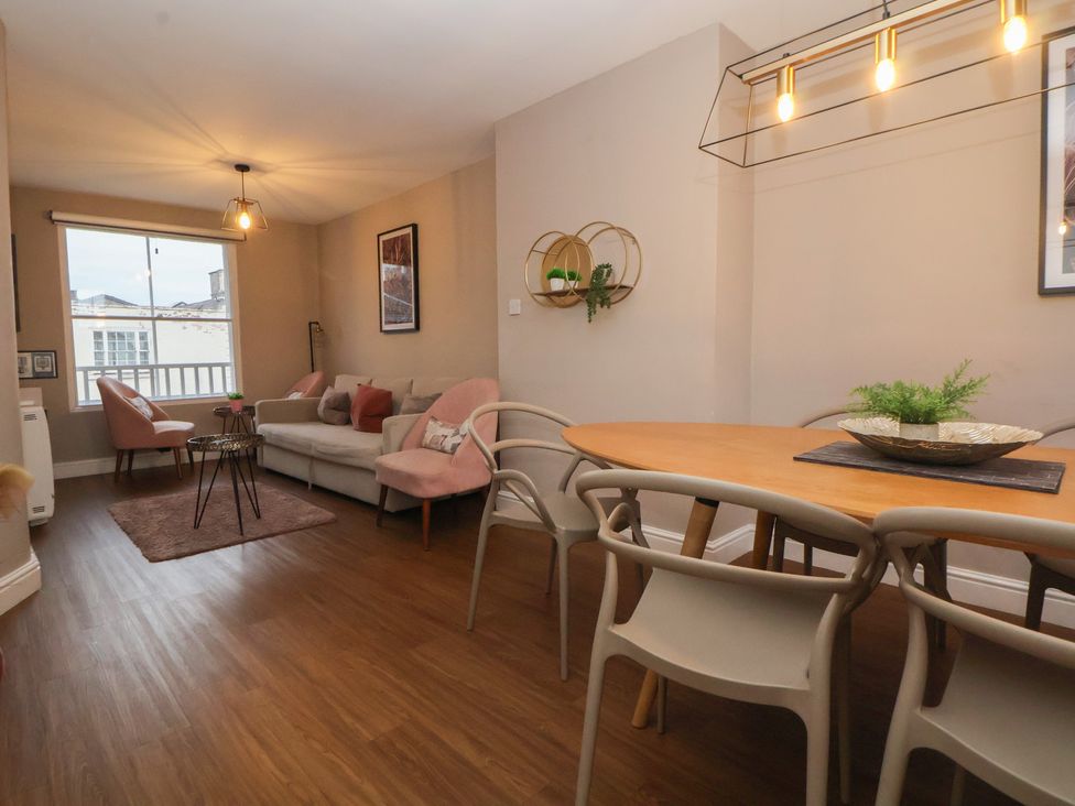 A living room with a dining area and windows at Ravenswood Penthouse in Chester