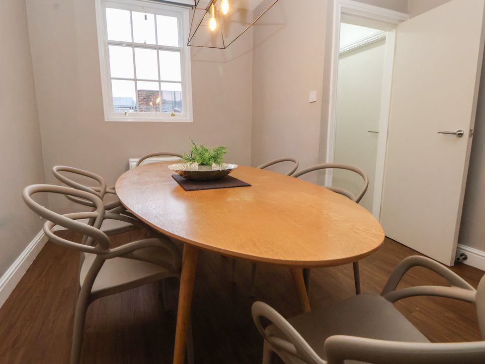 A dining room with an oval table and six chairs at Ravenswood Penthouse in Chester