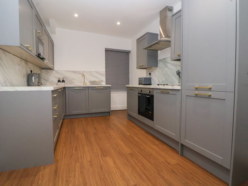A kitchen with gray cabinets and appliances at Ravenswood Penthouse Chester