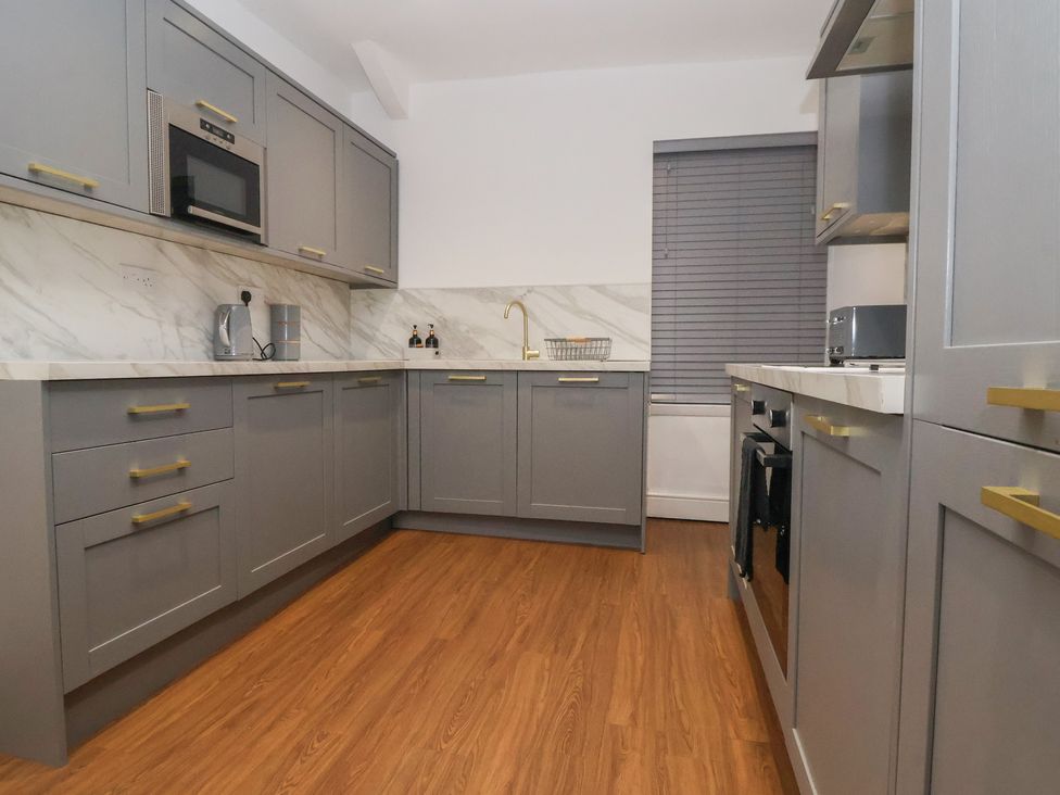 A kitchen with gray cabinets and appliances at Ravenswood Penthouse in Chester