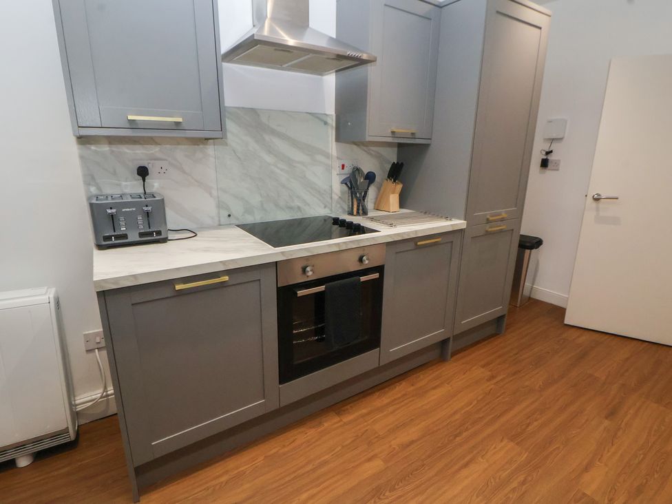 A kitchen with grey units and a cooktop at Ravenswood Penthouse in Chester